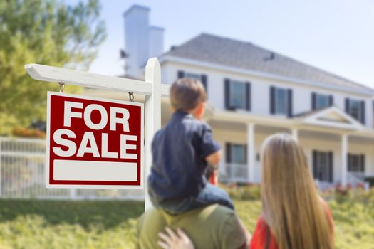 Curious Family Facing For Sale Real Estate Sign and Beautiful New House.