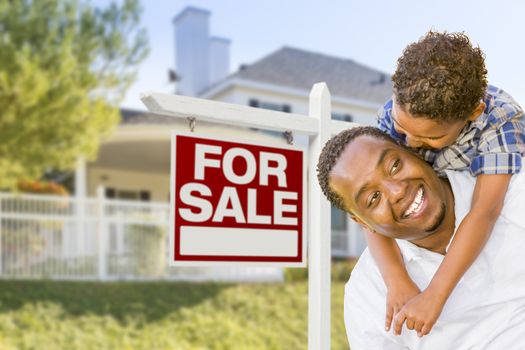 African American Father and Mixed Race Son In Front of Home For Sale Real Estate Sign and New House.