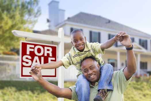 Happy African American Father and Son in Front of Home and For Sale Real Estate Sign.