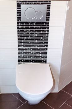  Wall hung WC in white in a modern day bathroom.