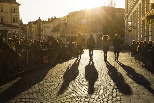 Ljubljana, Slovenia - October 30, 2014: People terracing (sitting, drinking coffee and people watching) in lively Ljubljana city center in the afternoon sun.