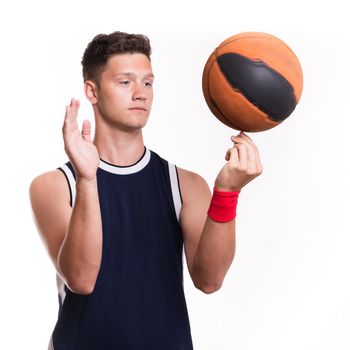 Basketball player spins the ball on his finger - studio shoot 