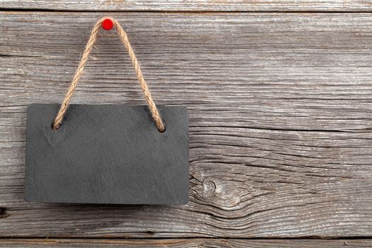 Black board of slate on old rustic wooden background.