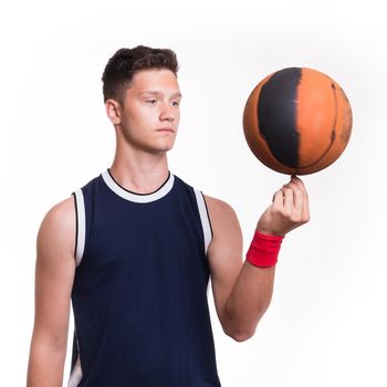 Basketball player spins the ball on his finger - studio shoot 