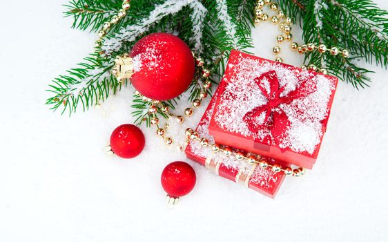 Christmas gift and balls on fir branches ,over white