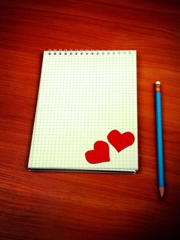 Toned Photo of Blank Writing Pad with Heart Shapes and Pencil On The Table