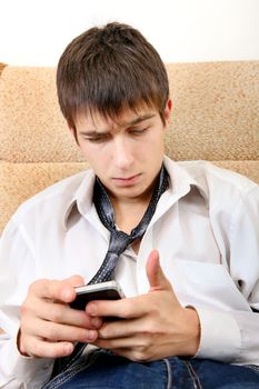 Sad Teenager with Cellphone on the Sofa at the Home