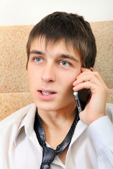 Stressed Teenager with Cellphone on the Sofa at the Home