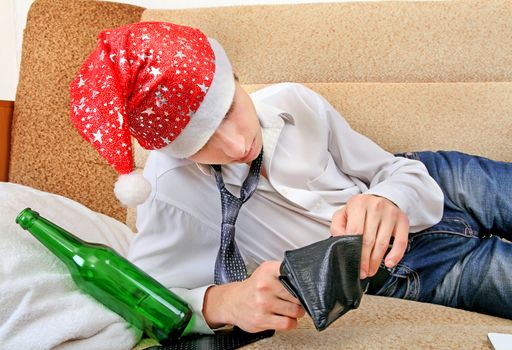 Teenager in Santa Hat Checking Empty Wallet after Party on the Sofa