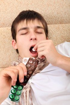 Sick Teenager taking a Pill on the Bed at the Home