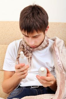 Sick Teenager choice the Medicine on the Sofa at the Home