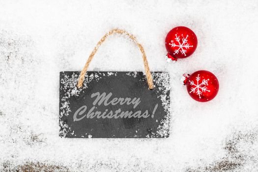 Black board of slate on rustic wooden background with snow