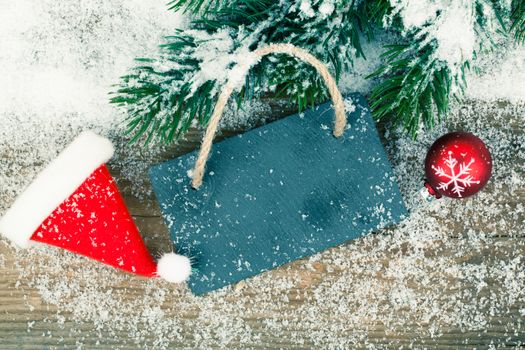 Black board of slate on rustic wooden background with snow