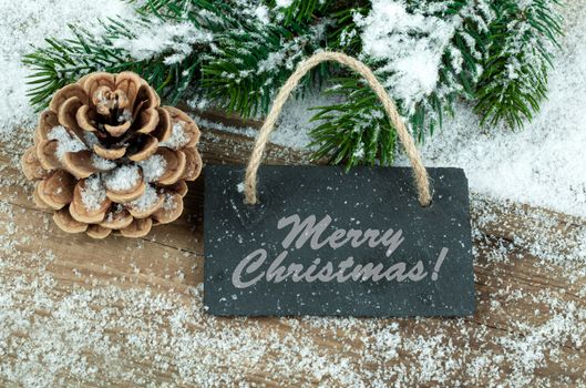 Black board of slate on old rustic wooden background, with snow