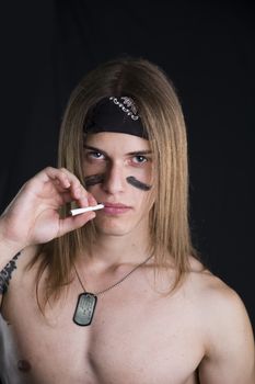 Shirtless male model wearing a bandanna smoking a cigarette