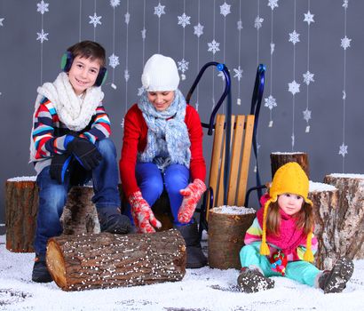 Winter Fashion. Adorable happy boy and girls in winter hat, gloves and sweater in studio.