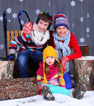 Winter Fashion. Adorable happy boy and girls in winter hat, gloves and sweater in studio.