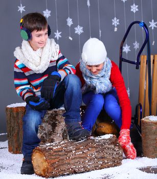 Winter Fashion. Adorable happy boy and girl in winter hat, gloves and sweater in studio.