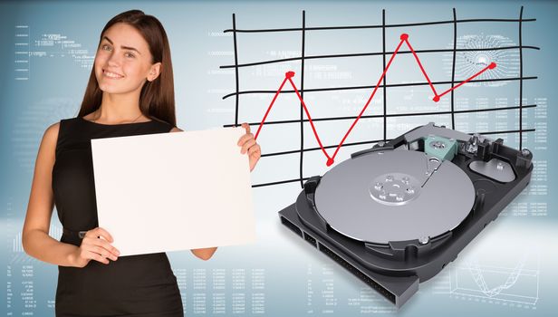 Smiling beautiful businesswoman in dress hold empty paper sheet. Open HDD are located near. Graph as backdrop