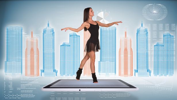 Beautiful woman dancer dancing on screen of tablet pc. Wire-frame business city and graphs as backdrop