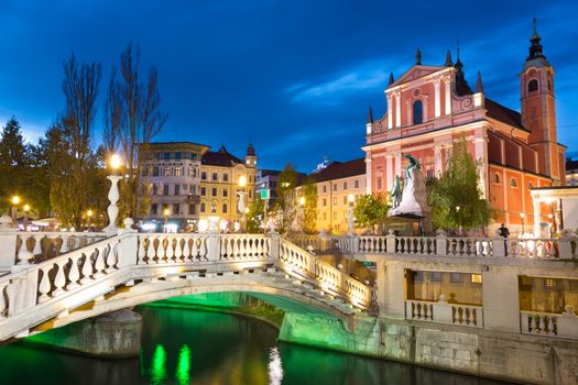 Romantic Ljubljana's city center at dusk. River Ljubljanica, Triple Bridge, Preseren square and Franciscan Church of the Annunciation. Ljubljana, Slovenia, Europe. 