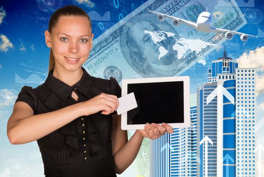 Beautiful businesswoman in dress holding tablet and white empty card near screen of tablet. Buildings, money, airplane and world map as backdrop