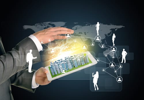 Man hands using tablet pc. Business city on touch screen. Network with business silhouettes near computer. Technology concept