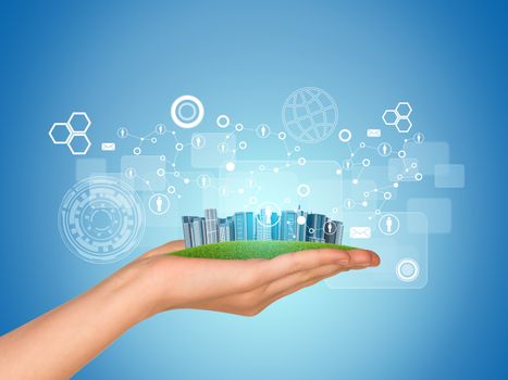 Hand holds city of skyscrapers. Network with people icons near hand. Business concept