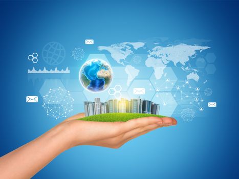 Hand holds city of skyscrapers. Earth globe, network and world map in background. Element of this image furnished by NASA