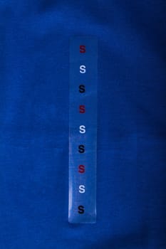 Label size S on blue cloth - Stock Image