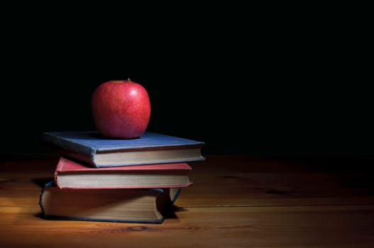 Apple on top of a stack of books with copyspace 