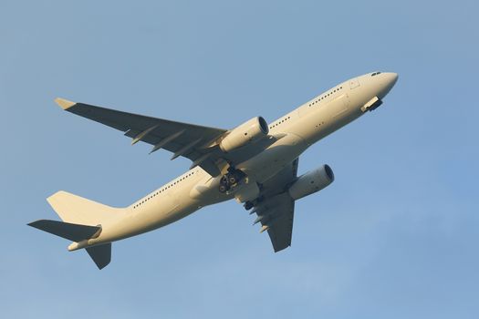 Airplane flying away to the blue sky