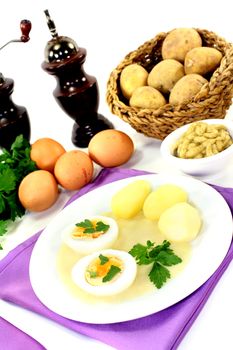 Mustard eggs with potatoes on bright background