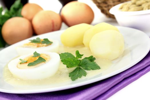 Mustard eggs with potatoes and smooth parsley on a light background