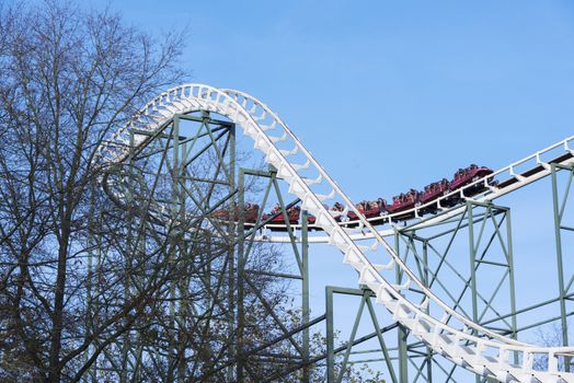 people in roller coaster on amusement park in holland