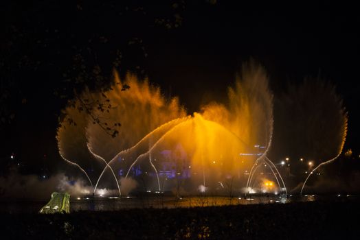 magic water fountain in gold and yellow colors during music show in holland