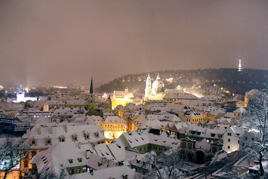 Photo shows Prague at winter night with its houses.