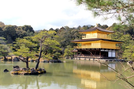Photo shows old Japanese golden temple in the middle of the park.