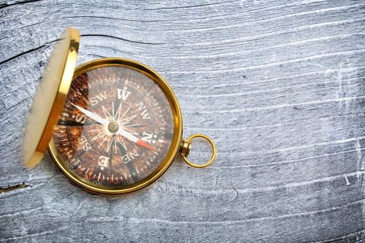 Compass on gray wooden background