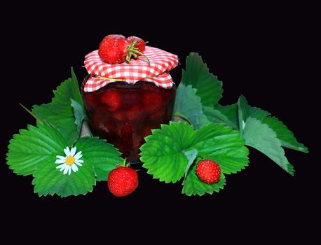 jar with strawberry jam and green leaves on the black background