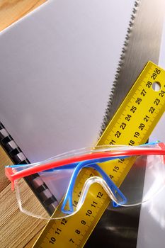 Ruler, notebook, handsaw and goggles