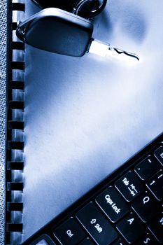 Notebook, car key and computer keyboard