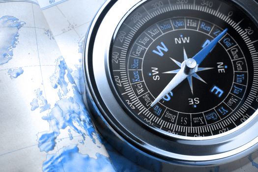 Compass on map background in blue toning