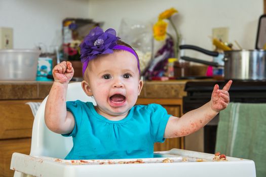 A baby girl throws a tantrum in the kitchen