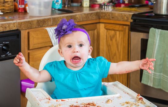 A talkative baby girl eating in the kitchen