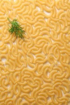 Short ribbed pasta tubes background with dill