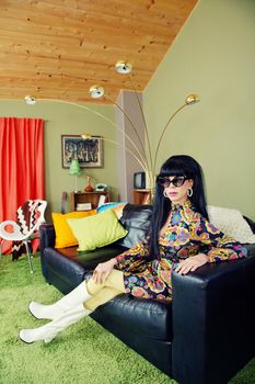 Calm groovy woman sitting on leather sofa