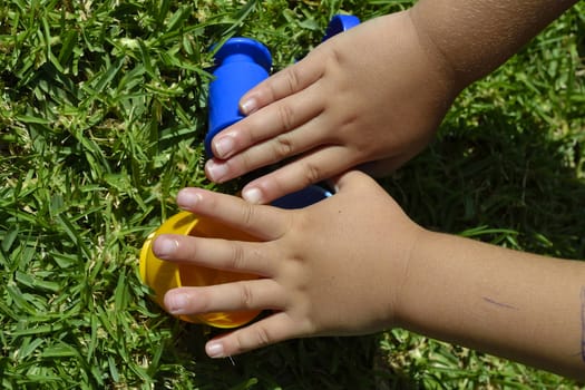 Hand of a child playing with colored plastic cups