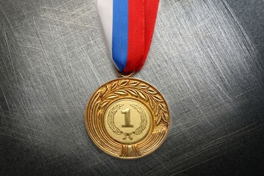 Metal medal with tricolor ribbon on steel scratchy background