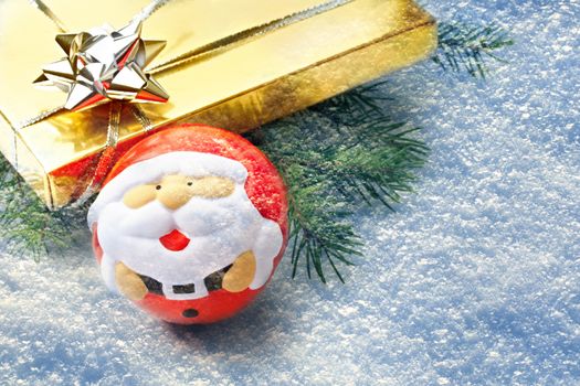 Gift with fir and santa ball on snow background